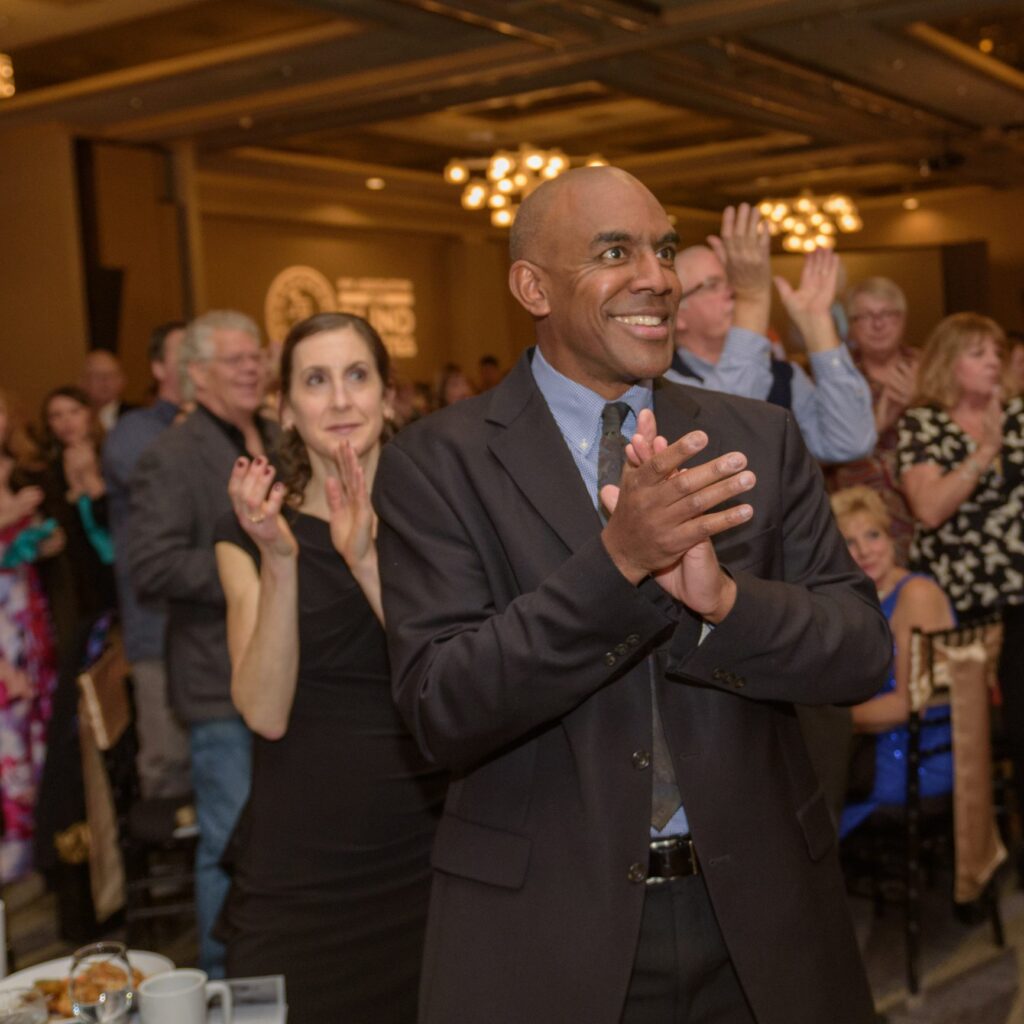CS Sheffield clapping in a crowd at NWABA's dinner and auction.